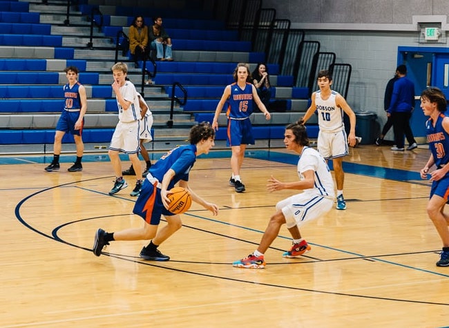 basketball player going 1 to 1 with another player and driving to the goal