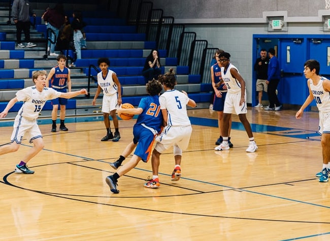 basketball player going 1 to 1 with another player and driving to the goal